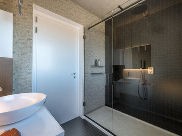 kúpelňa luxusná s priehľadným sprchovým kútom a širokými dverami